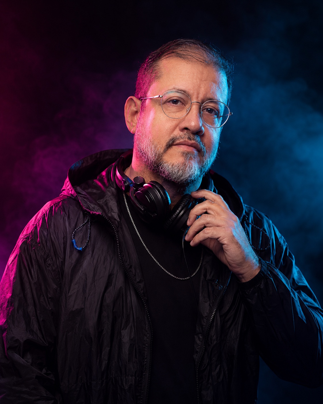 Retrato fechado de ROHBO com fone no pescoço sob luz magenta e azul